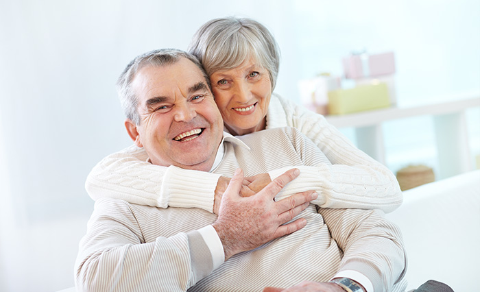 starší manželský pár sa objíma a usmieva sa do objektívu