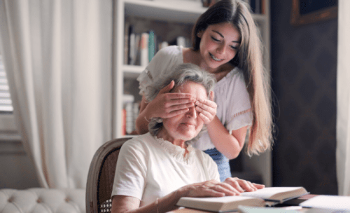 vnučka zakrýva starej mame oči pri čítaní